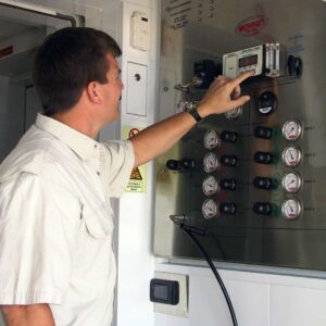 Technician operating custom LW Americas gas control panel for high-pressure compressor and oxygen system integration.