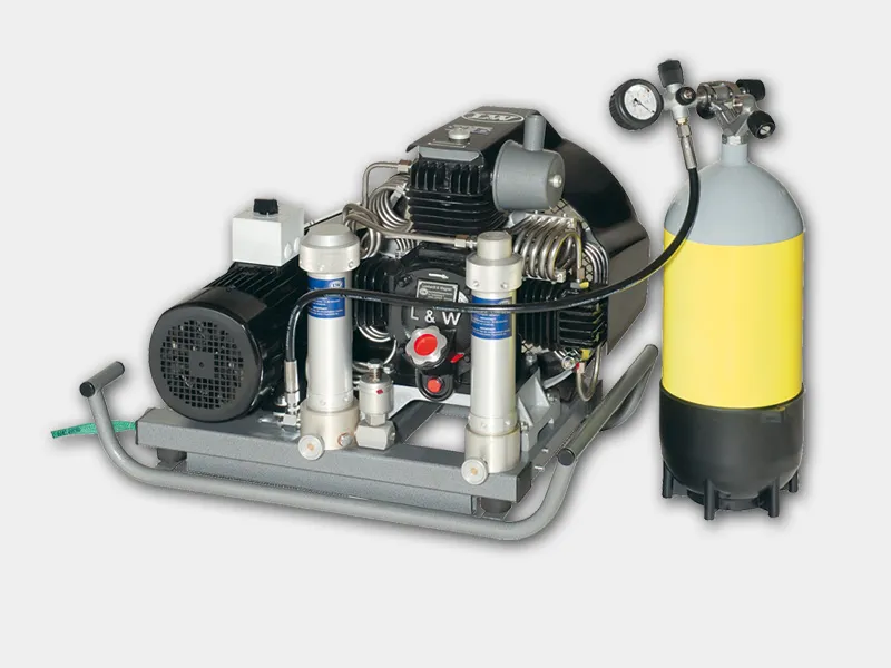 High-pressure air compressor system featuring L&W branding, with multi-stage components, attached storage tank, and integrated pressure gauge, illustrating ancillary equipment for industrial applications.